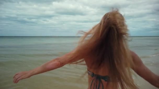 장난기많은 비키니를 선글라스를 여성이 돌아서서 해변을 뛰어다니는 — 비디오