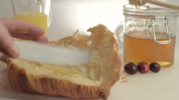 Hand Spreading Honey Fresh Baked Croissant Close Shot — Stock Video