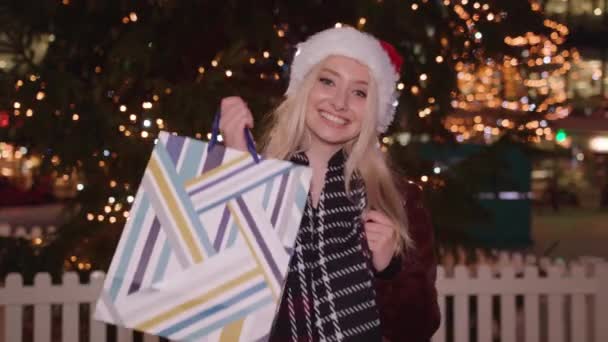 Young Woman Holds Her Shopping Purchase Twirls Smiles — Video
