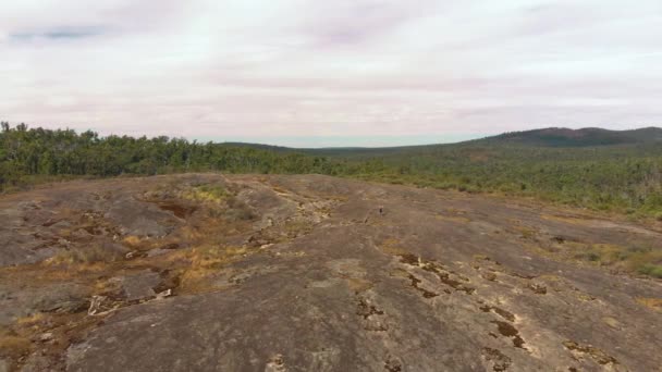 Aerial Drone Shot Hikers Descending Open Rockface Amidst Bushland — Stok video