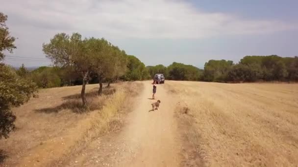 Woman Calling Dog Man Flying Drone Stopped Car Sandy Dirt — Stockvideo