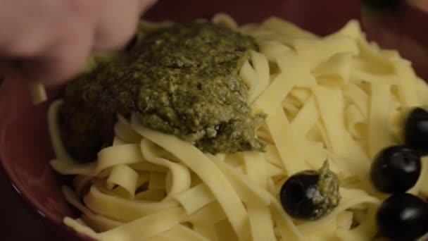 Serving Tagliatelle Pasta Green Pesto Sauce Black Olives Close Shot — Vídeos de Stock
