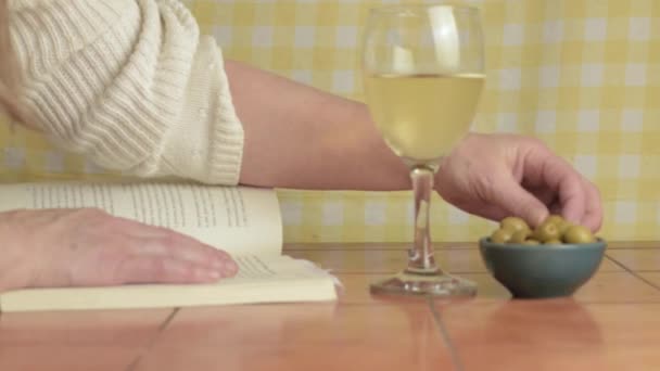 Reading Novel While Enjoying White Wine Olives Medium Shot — Stock Video