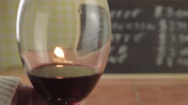 Hand Holding Glass Red Wine Candle Reflections Close Shot — Stockvideo