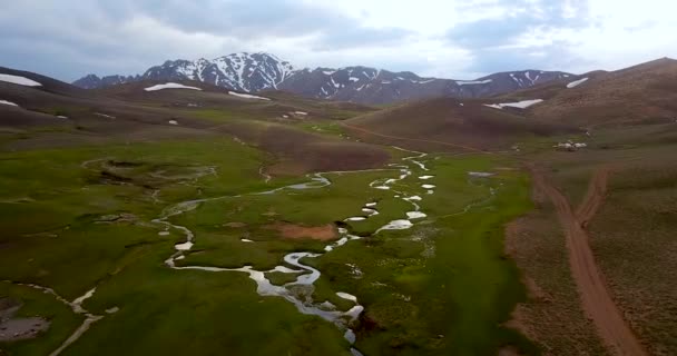 Aerial Green Highland Snowy Mountains Landscape Beautiful Stream Reflects Cloudy — Stockvideo