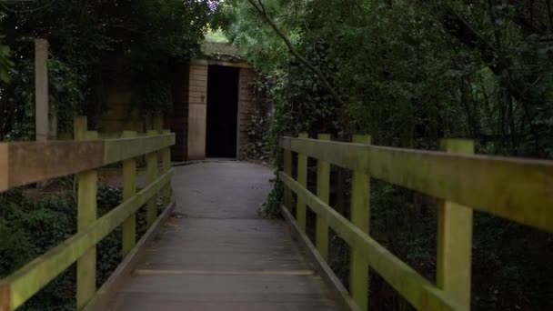 Walking Small Wooden Bridge Leading Doorway Wide Shot — Stockvideo