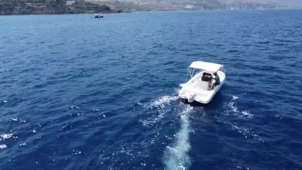 Two Men Riding Speedboat Cruising Deep Blue Sea Coastal Village — стоковое видео