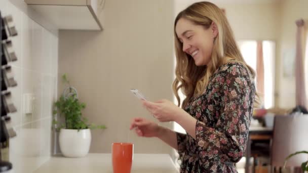 Râzând Fată Glisează Telefon Inteligent Timp Face Ceașcă Ceai Bucătărie — Videoclip de stoc