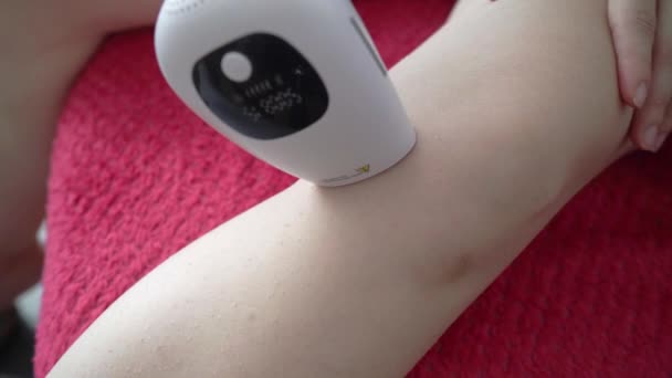 Woman Using Laser Hair Removal Device Her Knee Daytime Couch — ストック動画