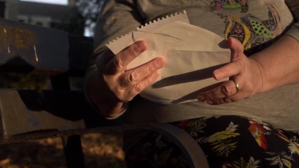 Mature Woman Reading Letter Sitting Park Bench Close Panning Shot — Vídeos de Stock