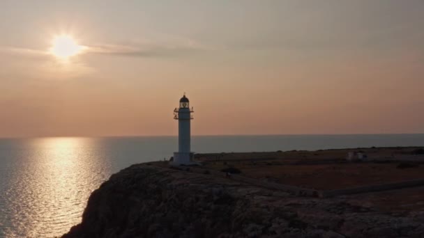 Sun Reflected Still Sea White Lighthouse Rocky Cliff Dolly Out — Vídeos de Stock