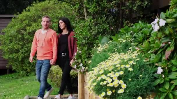 Jonge Latijnse Echtpaar Loopt Door Tuin Met Prachtige Bloemen Een — Stockvideo