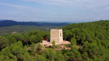 parallax aerial drone shot of soldiers tower in aviny green dense forest. Mountains of catalonia spain 