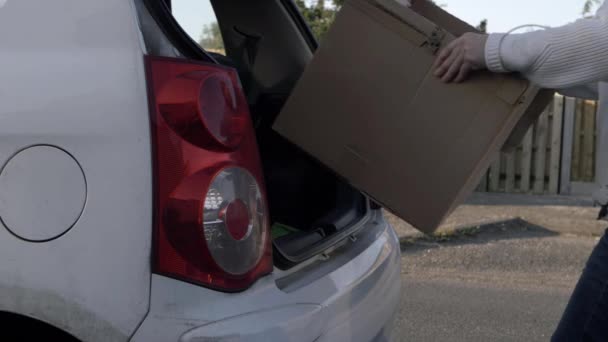 Woman Putting Cardboard Box Boot Car Wide Shot — Αρχείο Βίντεο