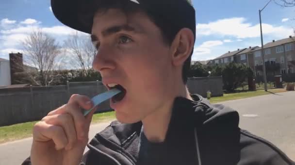 Man Putting Piece Chewing Gum Sidewalk Small Suburban Area – stockvideo