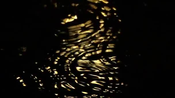 Conceptual Multiple Drops Water Producing Golden Ripples Black Surface — Stok video