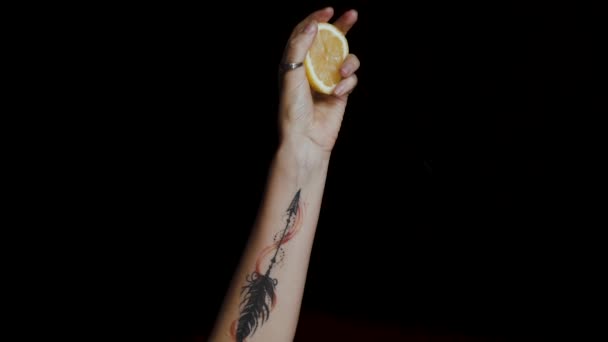 Close Female Hand Tattoo Squeezing Lemon Black Background — Vídeo de stock