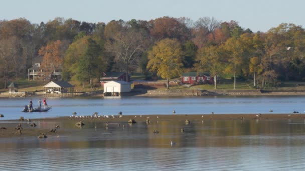 Men Fishing Boat Lake Sand Bar Birds Houses Background — Vídeo de Stock