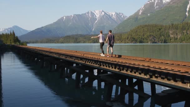 Молодая Счастливая Пара Прогулка Аляскинскому Железнодорожному Мосту Живописный Пейзаж Лагуны — стоковое видео