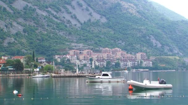 Fishing Boat Dinghy Anchored Water Coastal Town Buildings Mountains Back — 图库视频影像