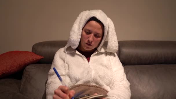 Woman Dressed Rabbit Pajamas Writing Agenda Mobile Sofa — Stockvideo