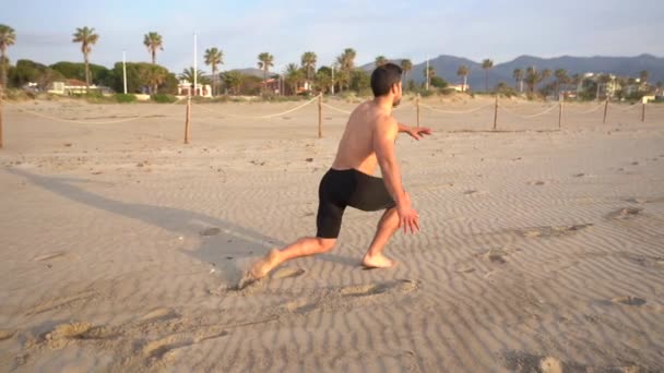 Muscular Athlete Training Legs Beach Doing Lunges Crouching — Stockvideo
