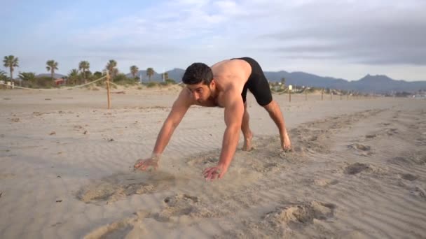 muscular athlete doing frog jumps shirtless on the beach metabolic training