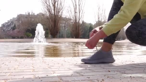 Mujer Deportiva Atando Sus Zapatillas Parque Con Una Bonita Fuente — Vídeos de Stock