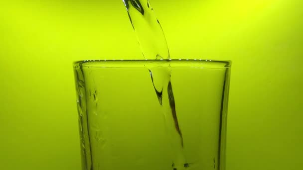 Close Shot Plastic Bottle Pouring Water Glass Green Background Static — Vídeos de Stock