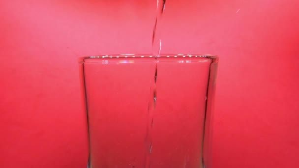 Κοντινό Πλάνο Του Ρίχνει Νερό Στο Γυαλί Ροζ Φόντο Στατική — Αρχείο Βίντεο
