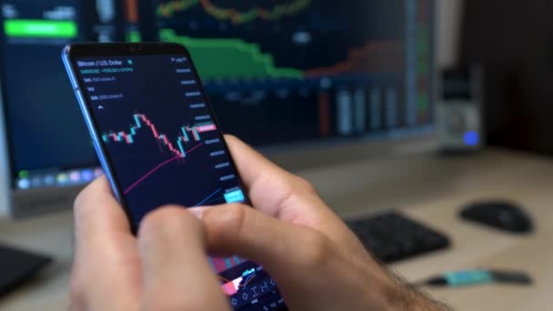 Trader Checks Bitcoin Market Price Graph Smart Phone Device Close — стоковое видео