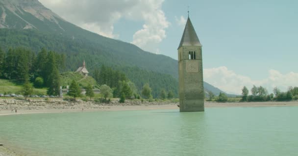 Vista Panorámica Gente Caminando Orilla Del Reschensee Día Soleado Brillante — Vídeo de stock