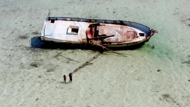 Αεροφωτογραφία Δύο Ανθρώπων Που Κοιτάζουν Σκουριασμένο Ναυάγιο Βρίσκεται Ρηχά Νερά — Αρχείο Βίντεο