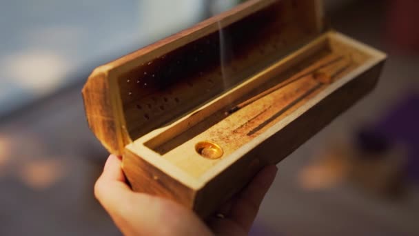 Hand Holding Wooden Box Burning Incense Sunset Light Yoga Studio — Stockvideo