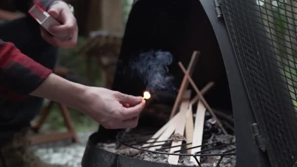 Young Adult Male Lights Match Brings Small Pile Wood Black — Stock video