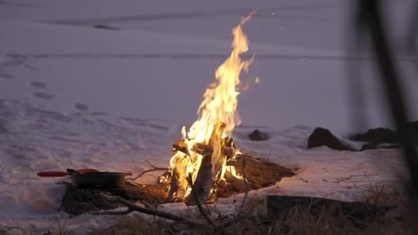 Φωτιά Στο Χιόνι Ενώ Κατασκηνώνουμε Ένα Τηγάνι — Αρχείο Βίντεο