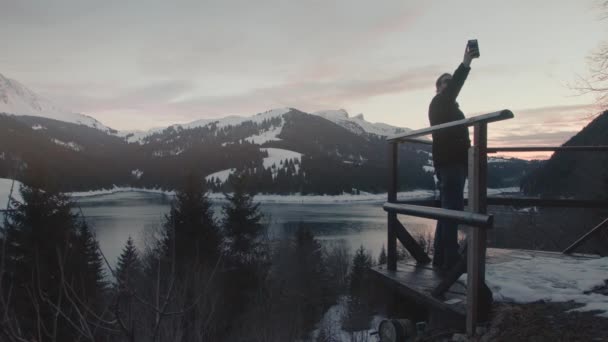 Millennial Man Standing Viewpoint Lookout Taking Selfie Snow Capped Mountains — Video Stock