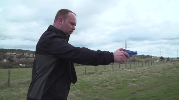 Man Shaky Arm Holds Blue Toy Pistol Gun — Vídeo de Stock