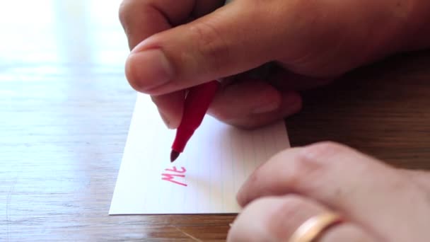 男性の手が小さな紙の上にペンでメモを書き — ストック動画