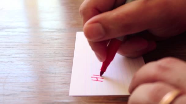 男性の手が小さな紙の上にペンでメモを書き — ストック動画