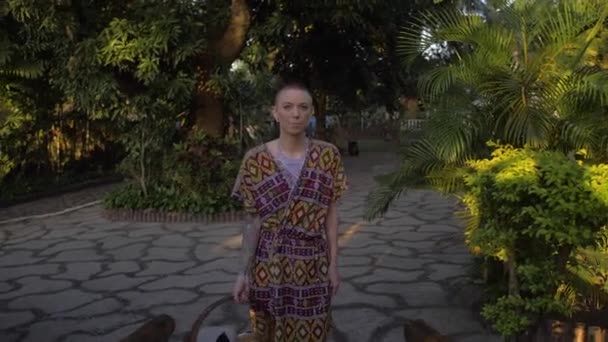 Tracking Shot Stunning Caucasian Woman Native Outfit Walking Tropical Garden — стоковое видео