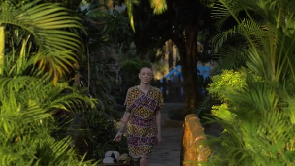 Beautiful Female Model Wearing Native Robe Walks Tropical Garden Warm — стоковое видео
