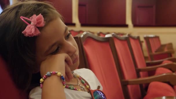 Bored Little Girl Sitting Theatre Seat Watching Screen Stage — Stockvideo
