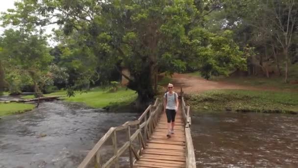 Aerial Tracking Shot Young Blonde Woman Walking Wooden Footbridge River — Vídeos de Stock