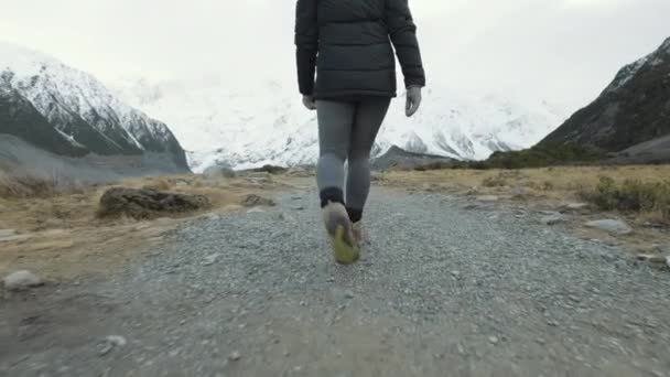 Low Angle Follow Shot Woman Hiking Snow Capped Mountains Cold — Vídeo de Stock