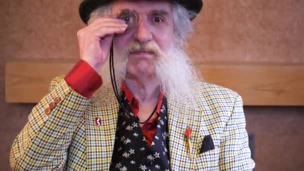 Older Man Beard Monocle Hat Points Camera — ストック動画
