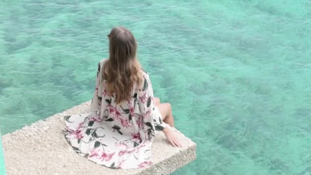 Young Woman Long Brown Hair Floral Dress Sitting Legs Swinging — Stock Video