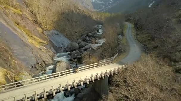 Man Standing Wooden Bridge Enjoys View Norwegian River Running Him — Stock videók