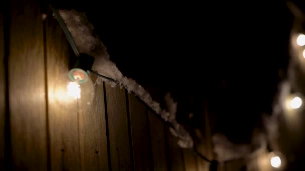 Outdoor Patio Lights Hanging Fence Covered Snow Slow Motion Pan — ストック動画