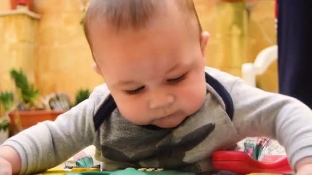 Close Cute Baby Playing Toy Telephone His Walker Looks Camera — Video